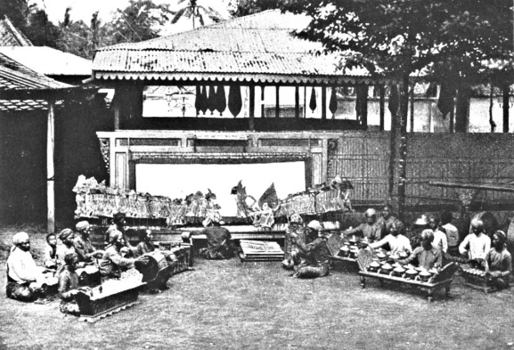 Wayang kulit di teater terbuka. (Mereka sedang menunggu datang- nya malam karena bayangan wayang dilihat dari belakang). Carpenter, Frank G., Java and the East Indies, Doubleday, Page & Scott Co., Garden City-New York 1926